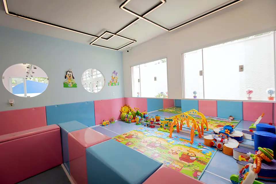 Sala de estimulação com piso e paredes acolchoadas em azul e rosa