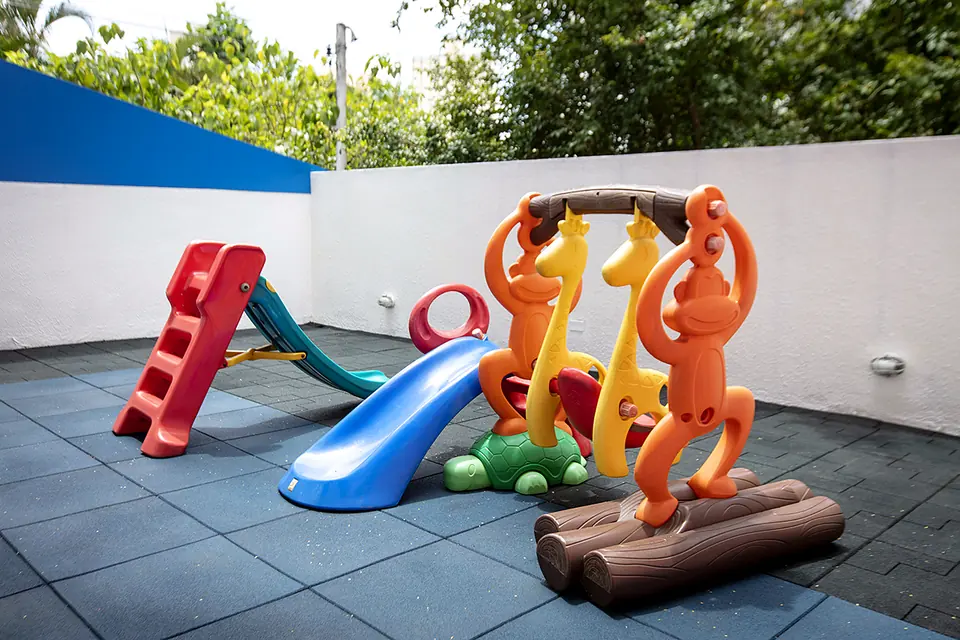 Parquinho coberto com escorregador e brinquedos coloridos